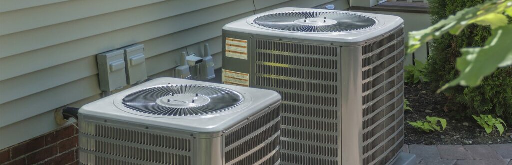 Two HVAC units next to a home.